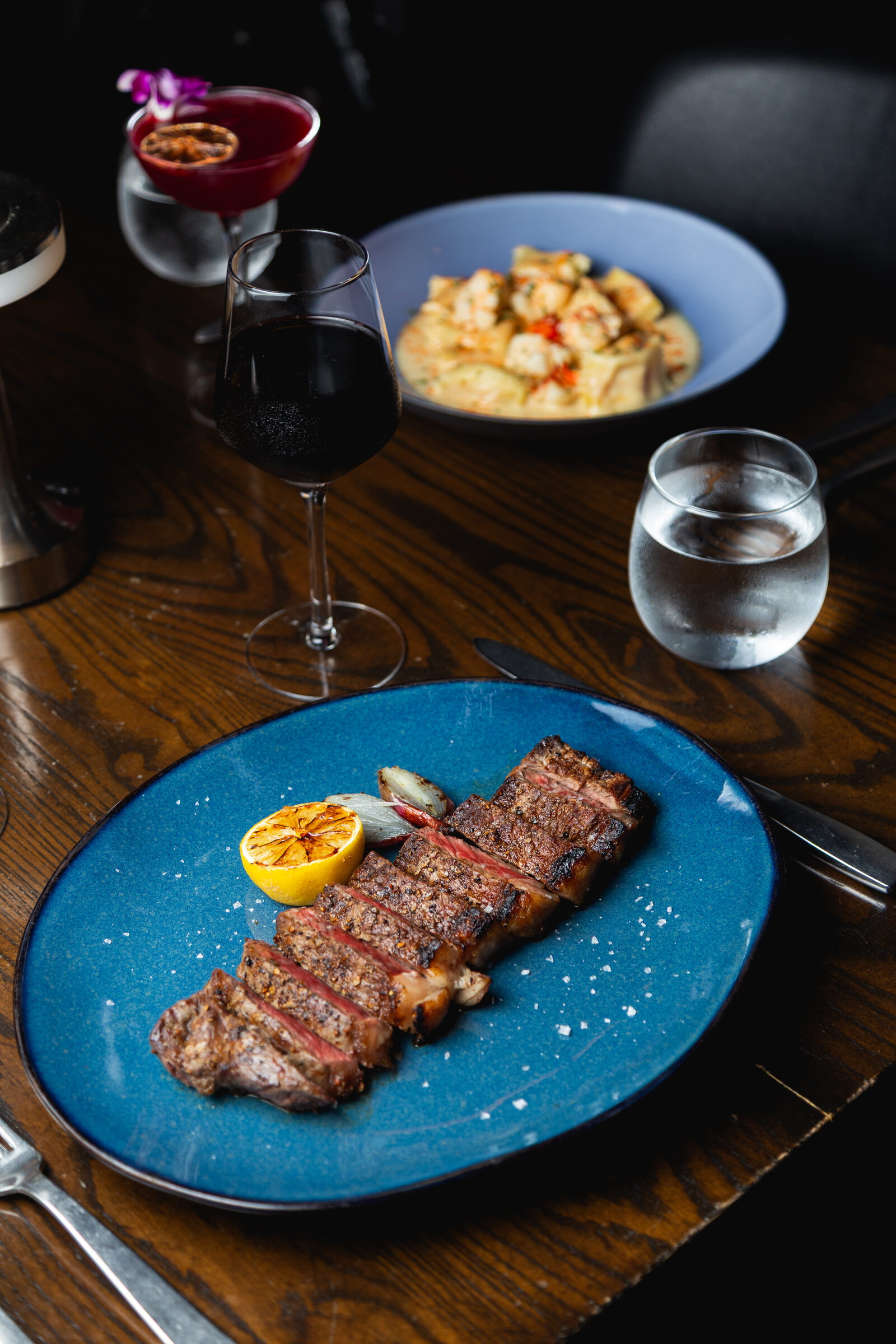 A sliced steak on a table set for a celebration dinner